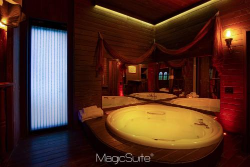 a large bathroom with two tubs and a large window at Hotel Carosello in Pontecagnano