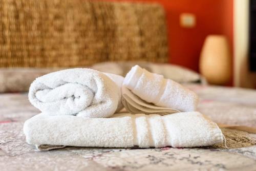 a pile of towels sitting on top of a bed at [Double Suite] - Prestige and Deluxe in Naples