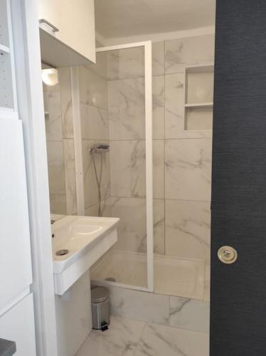 une salle de bain blanche avec un lavabo et une douche dans l'établissement Superbe appartement en plein centre ville, à Viarmes