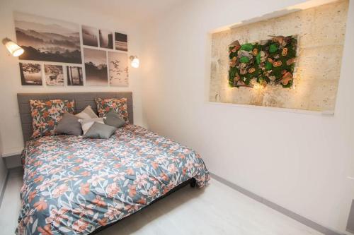 a bedroom with a bed and a painting on the wall at L'etoile : Beau T3 rénové /Wifi in Angoulême