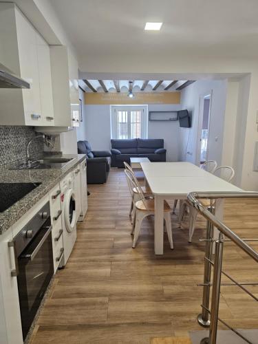 a kitchen and living room with a table and a couch at Apartamentos Plaza Santo Domingo in Cádiz