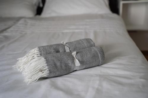 two gray towels sitting on top of a bed at 9b The Appartments in Trieste