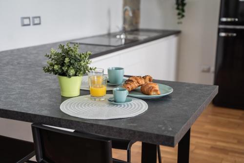 a table with a plate of food and two glasses of orange juice at 9b The Appartments in Trieste
