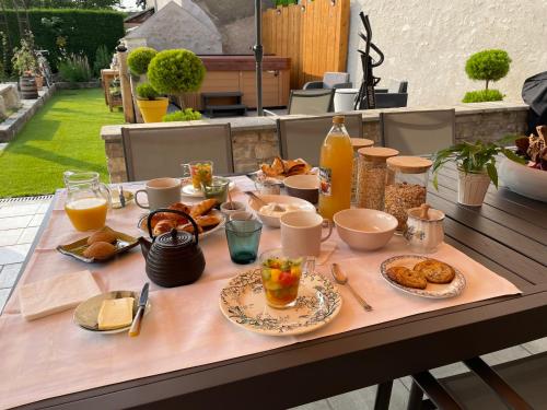 uma mesa com alimentos e bebidas para o pequeno almoço em Le Clos du Q’hâtre em Cléry-Saint-André