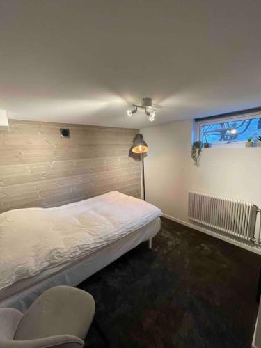 a bedroom with a bed and a chair and a window at Villa Valjensa in Sölvesborg
