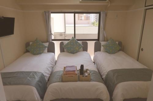 a group of three beds in a small room at 江元浅草 in Tokyo