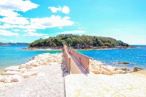 a boardwalk on a beach next to the water at Nilda 2 in Funtana