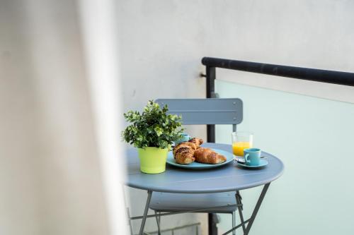 a table with a plate of croissants and orange juice at 9b The Appartments in Trieste