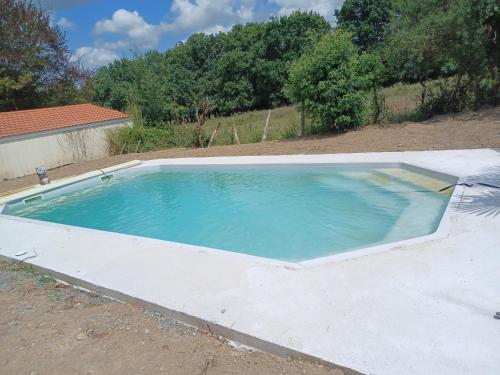 a large swimming pool in a yard at Maison avec piscine et spa gonflable, 2 chats présents in Saint-Étienne-de-Montluc