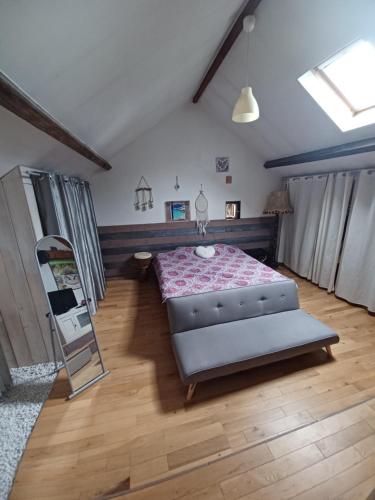 een slaapkamer met een bed en een spiegel bij Maison avec piscine et spa gonflable, 2 chats présents in Saint-Étienne-de-Montluc