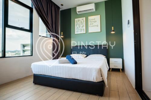 a bedroom with a large white bed with a green wall at ITCC Manhattan Suites by Calvin in Donggongon