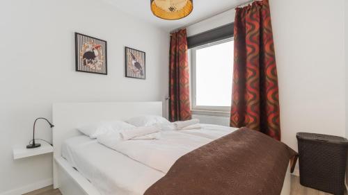 a bedroom with a white bed and a window at Bursztynowe Osiedle Jantar, Sun & Snow in Jantar