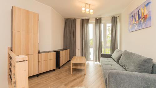 a living room with a couch and a table at Bursztynowe Osiedle Jantar, Sun & Snow in Jantar