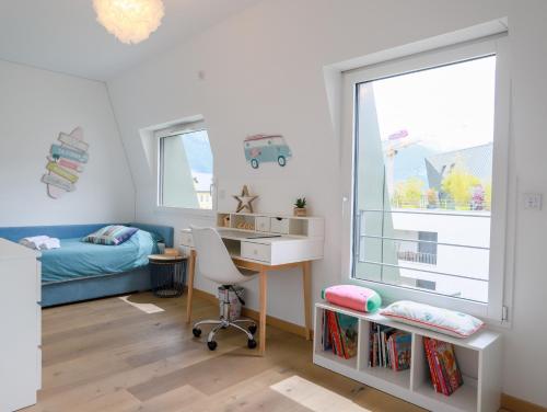 1 dormitorio con escritorio, 1 cama y ventana en Le Bleu Du Lac 3 étoiles - Secteur recherché, Calme & familiale, à 300m du lac & de la vieille ville, Garage privé, en Annecy