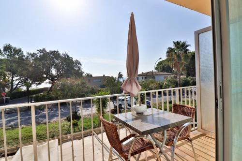 a patio with a table and chairs on a balcony at Hotel Le Golfe Bleu in Cavalaire-sur-Mer