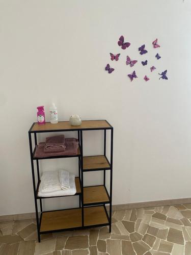 a shelf with purple butterflies on a wall at Appartamento " Le Farfalle " in Santorso