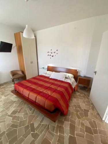 een slaapkamer met een bed met een rood dekbed bij Appartamento " Le Farfalle " in Santorso