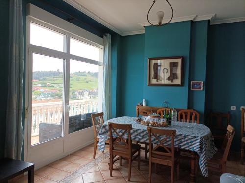 comedor con mesa, sillas y ventana en La Cariñosa en Naveces