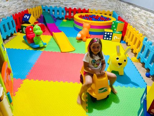 a little girl sitting on a toy car in a play room at Impero Hotel Beauty & Spa - Bike Hotel in Cantello