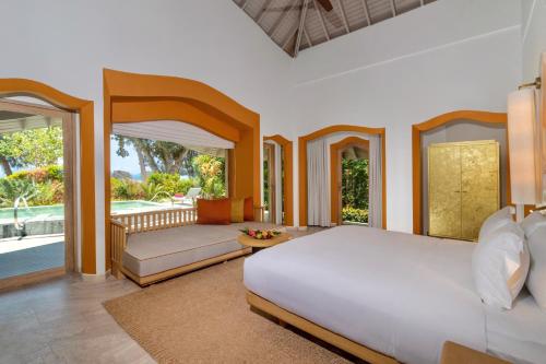 a bedroom with a large bed and a balcony at Phulay Bay, A Ritz-Carlton Reserve in Tab Kaek Beach