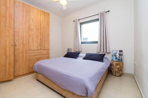 ein Schlafzimmer mit einem großen Bett und einem Fenster in der Unterkunft 2 rooms close to beach in Tel Aviv