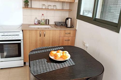 eine Küche mit einem Tisch mit einem Teller Orangen darauf in der Unterkunft 2 rooms close to beach in Tel Aviv