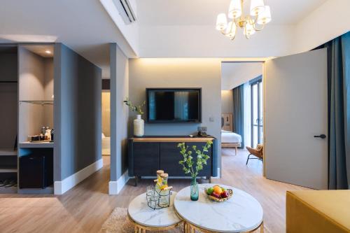 a living room with a television and a table at Bandalo Boutique Hotel - Patong Beach Road in Patong Beach