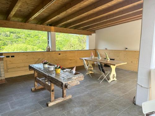 ein großes Zimmer mit einem Tisch und einer Bank in der Unterkunft Al bosco incantato in Triest