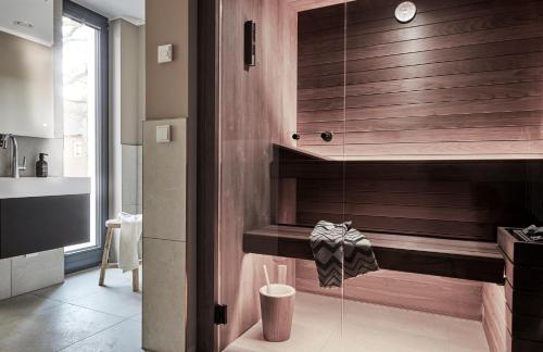 a bathroom with a shower with a wooden wall at Villa Baltique in Ostseebad Sellin