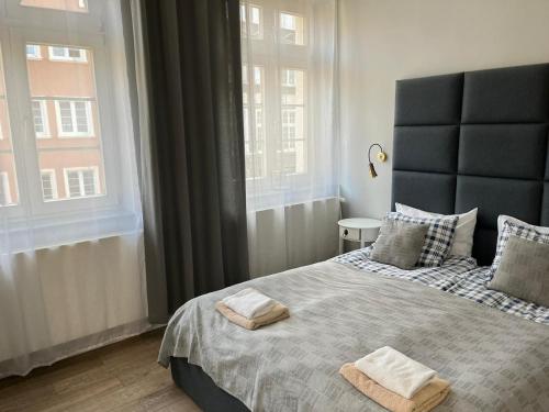 1 dormitorio con 1 cama grande y 2 toallas. en Old Gdansk No 8 en Gdansk