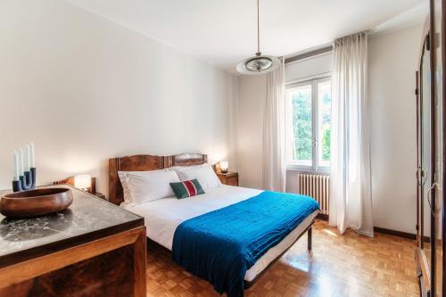 ein Schlafzimmer mit einem großen Bett und einem Fenster in der Unterkunft Mulino Nuovo by Quokka 360 - spacious apartment on the Swiss border in Como