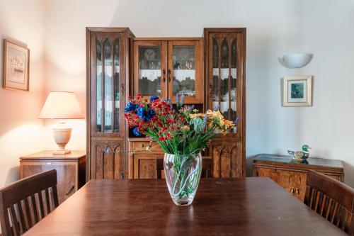 a vase of flowers sitting on a wooden table at Mulino Nuovo by Quokka 360 - spacious apartment on the Swiss border in Como