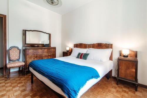 a bedroom with a large bed with a blue blanket at Mulino Nuovo by Quokka 360 - spacious apartment on the Swiss border in Como