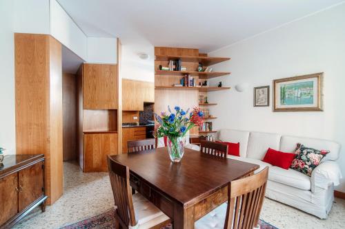 un soggiorno con tavolo e vaso di fiori di Mulino Nuovo by Quokka 360 - spacious apartment on the Swiss border a Como