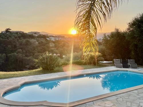 - une piscine avec vue sur le coucher du soleil en arrière-plan dans l'établissement Villa SYAGRUS - Easy Home Booking, à Nice