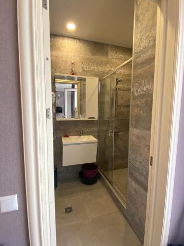 a bathroom with a shower and a sink and a mirror at 1st line apartment in Kobuleti in K'obulet'i