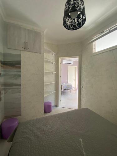a bedroom with a bed and a chandelier at 1st line apartment in Kobuleti in K'obulet'i