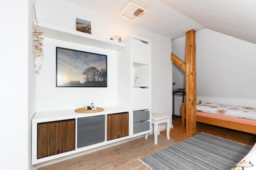 a bathroom with a sink and a bed in a room at Ferienwohnung im Haus Windrose in Wittmund