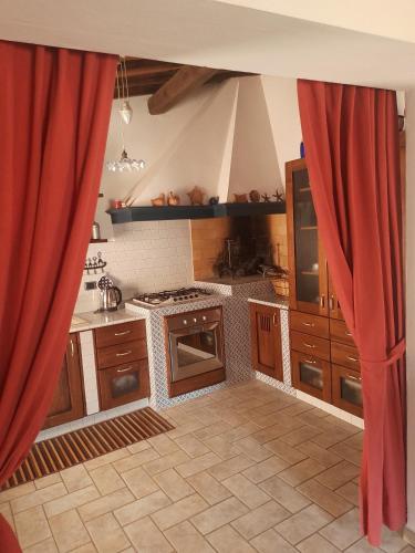 a kitchen with red drapes in front of a kitchen at casadipaola in Gambassi Terme