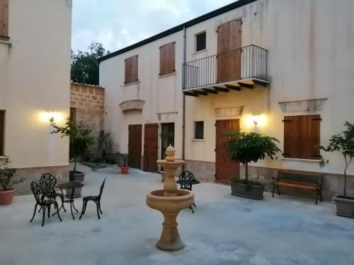 cortile con fontana di fronte a un edificio di Baglio delle Rondini - Piano Terra a Bagheria