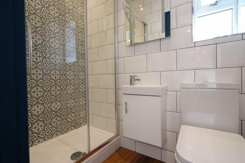 a bathroom with a shower and a toilet and a sink at 4 Bedroom Town House in Macclesfield