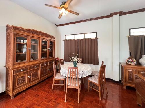 une salle à manger avec une table et une armoire dans l'établissement บ้านไทยไออุ่น, à Phra Nakhon Si Ayutthaya