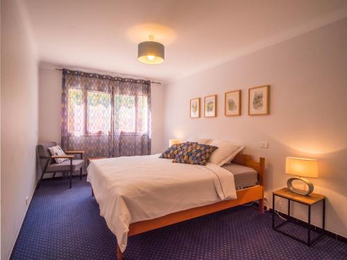 een slaapkamer met een bed, 2 lampen en een raam bij Camping Hotel Les Rives du Loup in Tourrettes-sur-Loup
