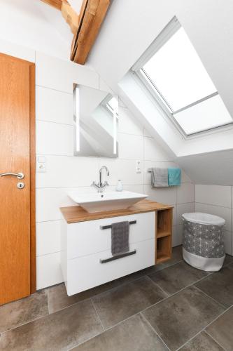 a bathroom with a sink and a skylight at Ferienwohnung im Haus Windrose in Wittmund