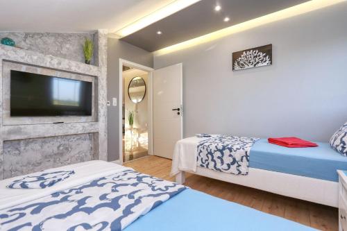 a bedroom with two beds and a flat screen tv at App 5 Zaton beach Sonnenterrasse Fußbodenheizung einzigartig auch im Herbst und Winter in Zaton
