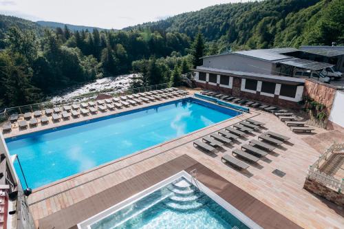 an overhead view of a swimming pool with chairs and a building at MORVA Premium Spa Resort in Yaremche