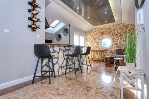 a bar with stools in a room with a stone wall at App 5 Zaton beach Sonnenterrasse Fußbodenheizung einzigartig auch im Herbst und Winter in Zaton