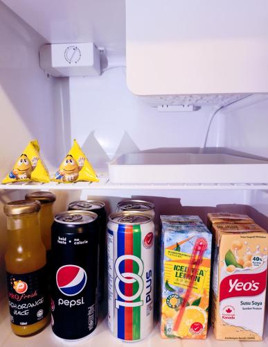 an open refrigerator filled with soda cans and snacks at Sunway Hotel Georgetown Penang in George Town