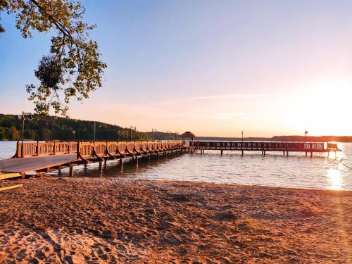 a dock on the water at sunset at Cztery Pory Roku in Wiele