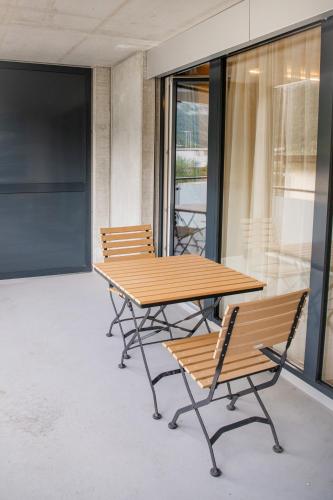 a wooden table and two chairs on a balcony at WAZ Wohnen auf Zeit - Flums in Flums
